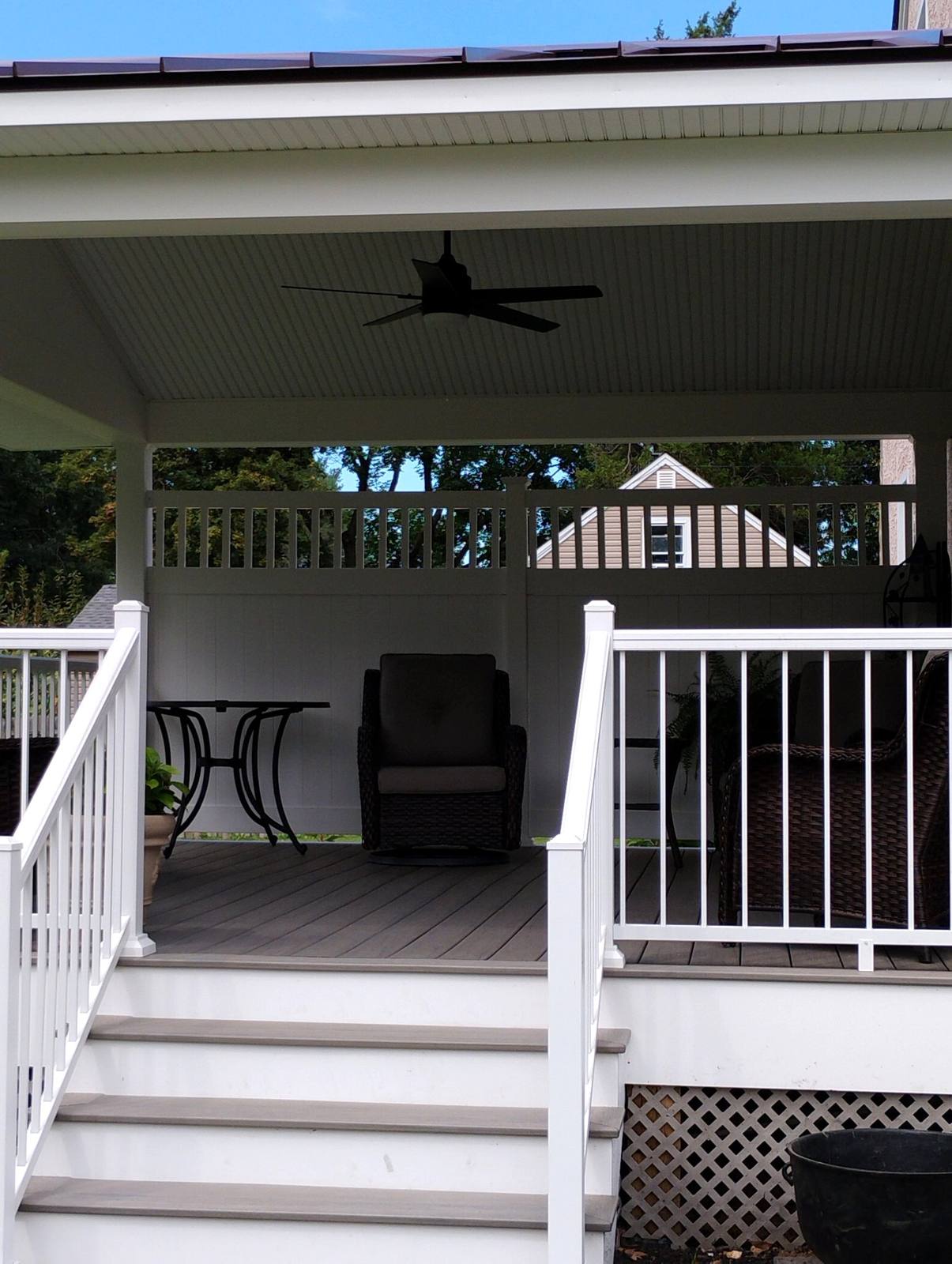 Furnished covered porch with white railings