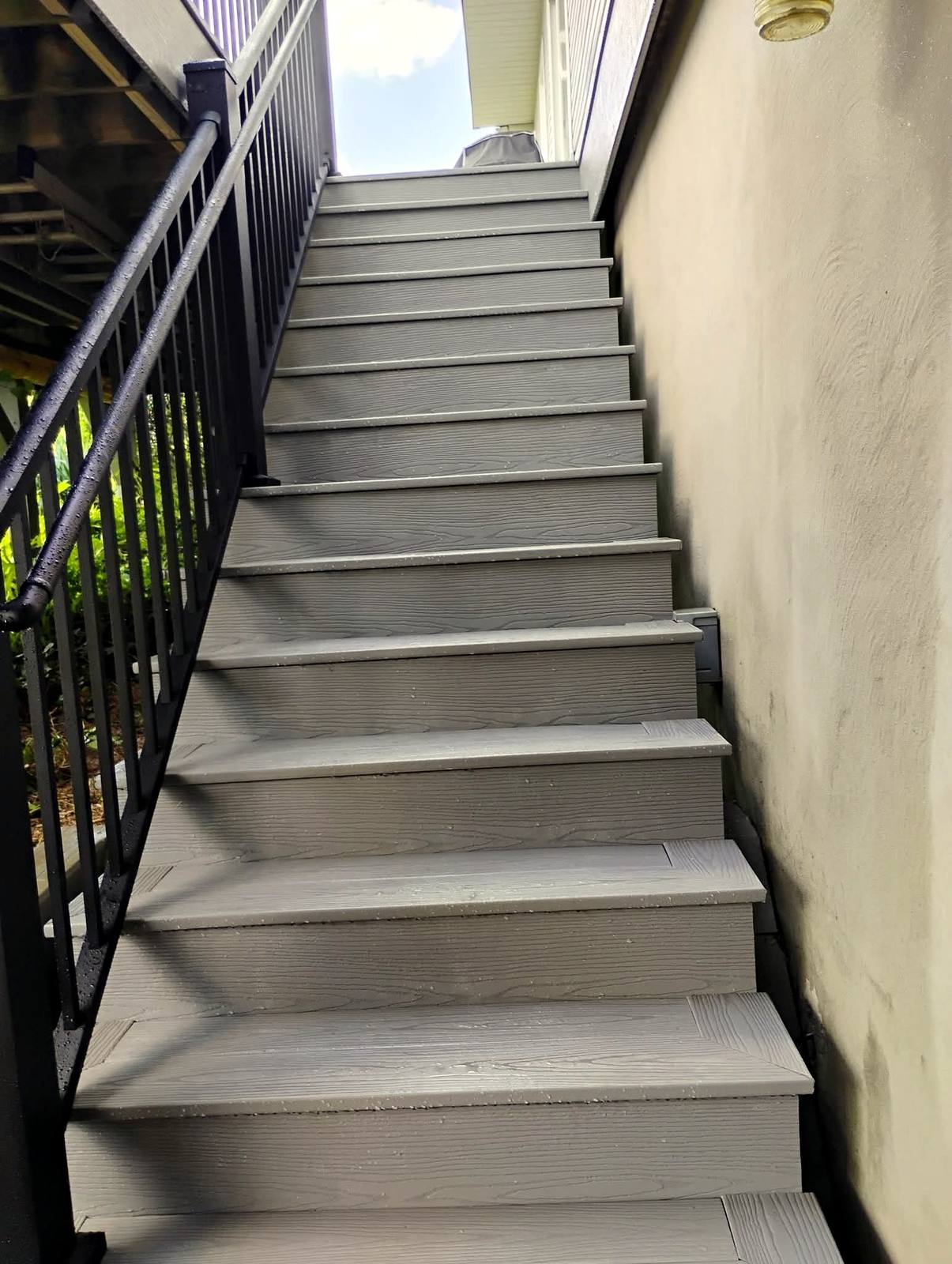 Gray composite staircase with black metal railing