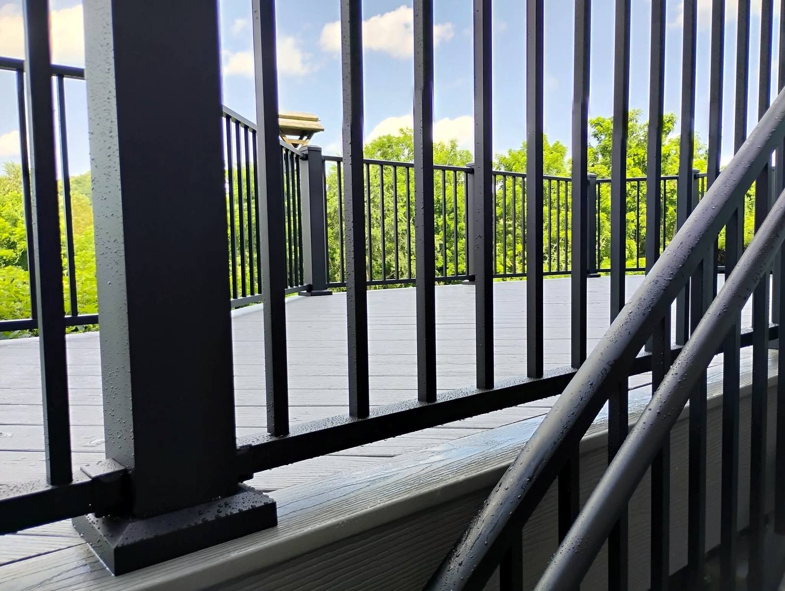 Black metal railing on a gray composite deck