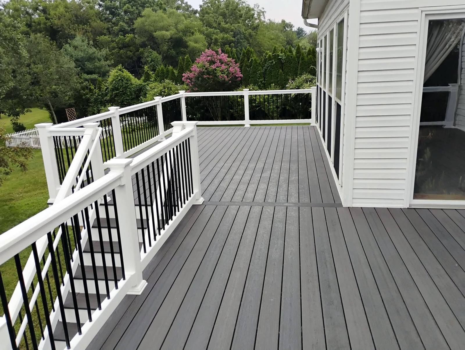 Gray composite deck with white posts and black balusters