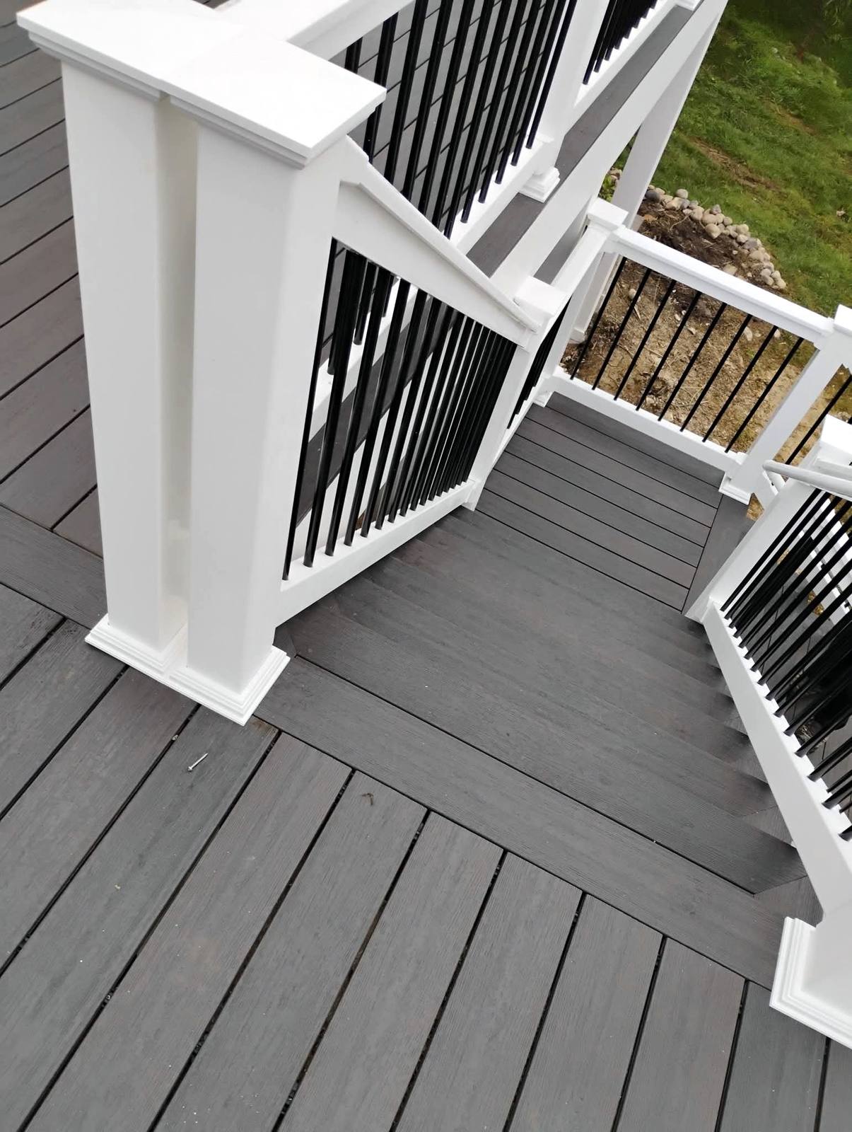 Composite deck corner with white post and black balusters