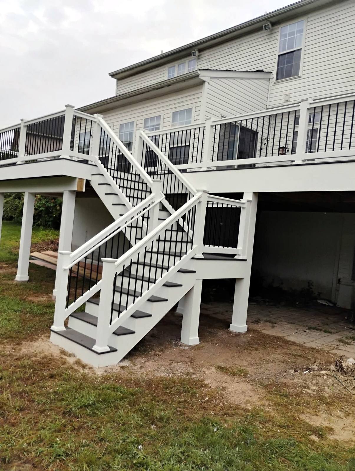Raised deck staircase with black balusters and white posts
