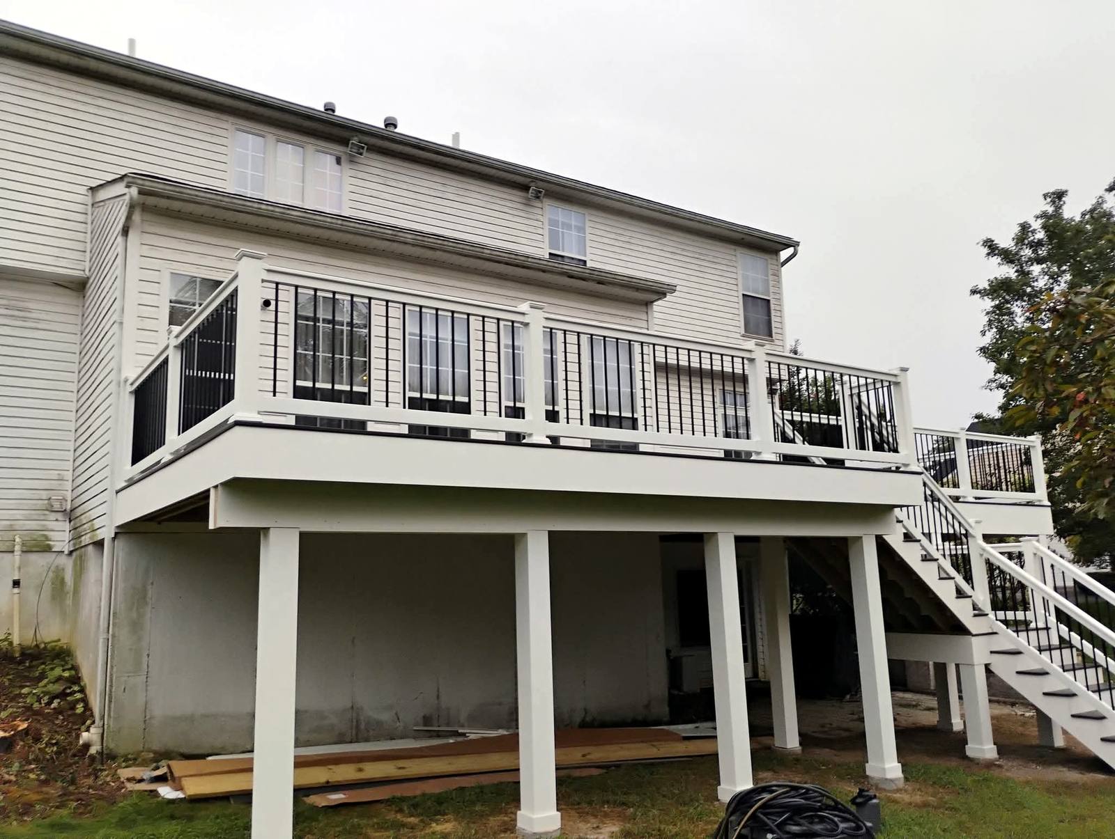 Raised gray deck with black railings and exterior stairs