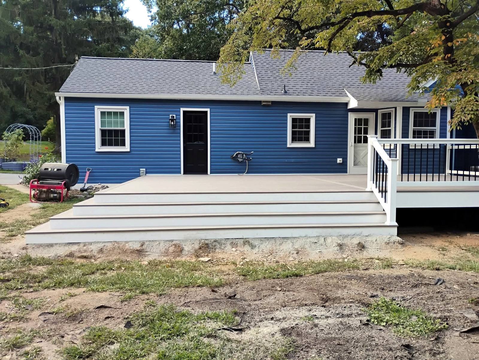 Finished deck and white staircase on a blue home