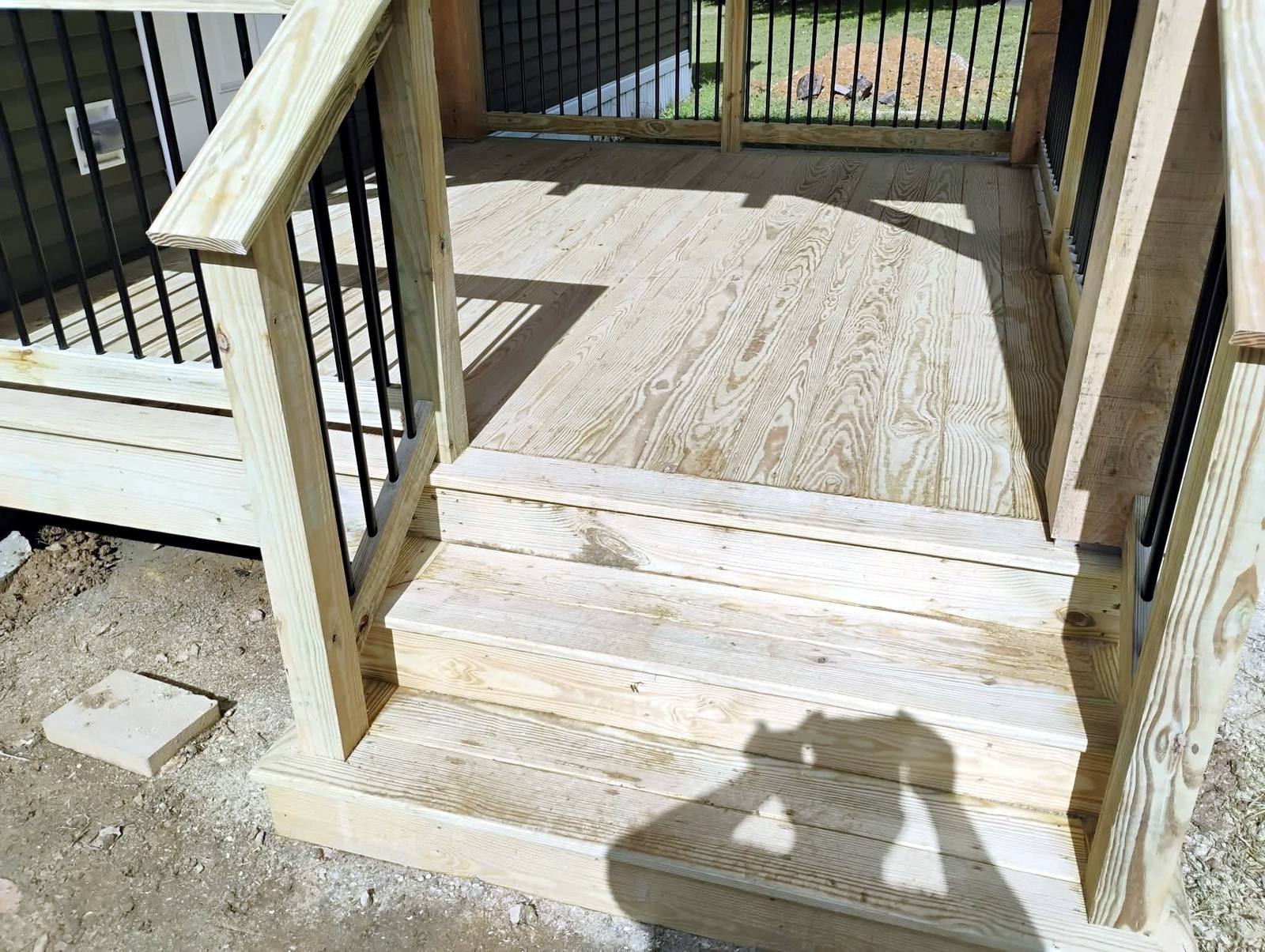 Finished porch floor and white railing detail