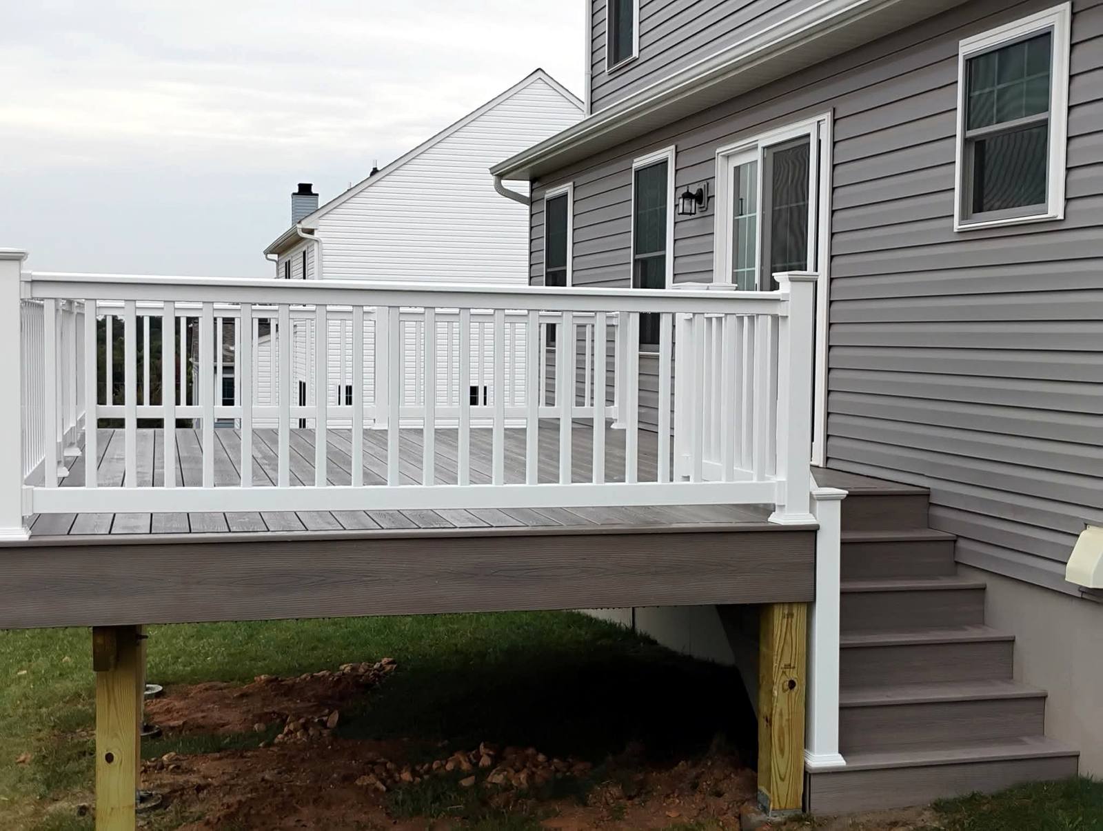 Second-story deck with white railings and stairs