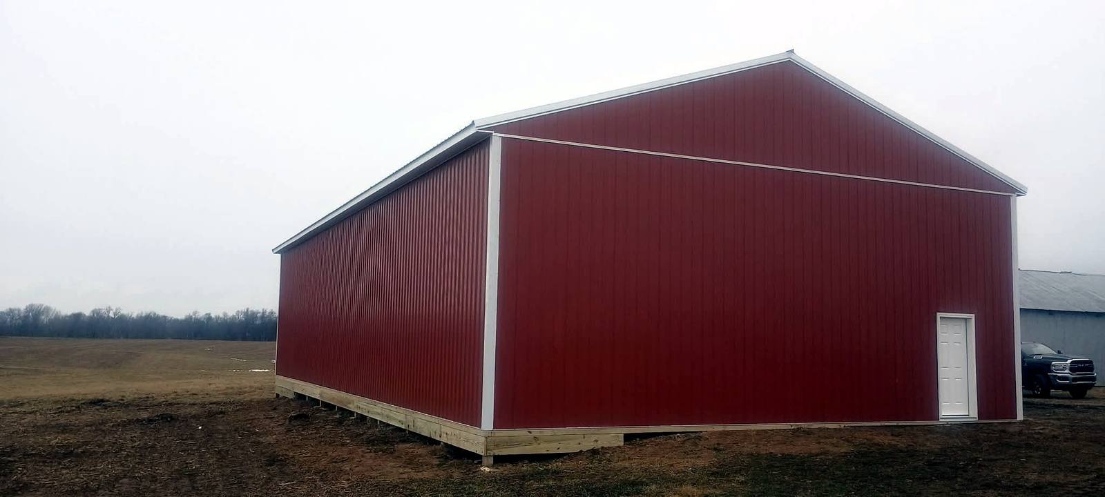 Completed red pole barn with white roof