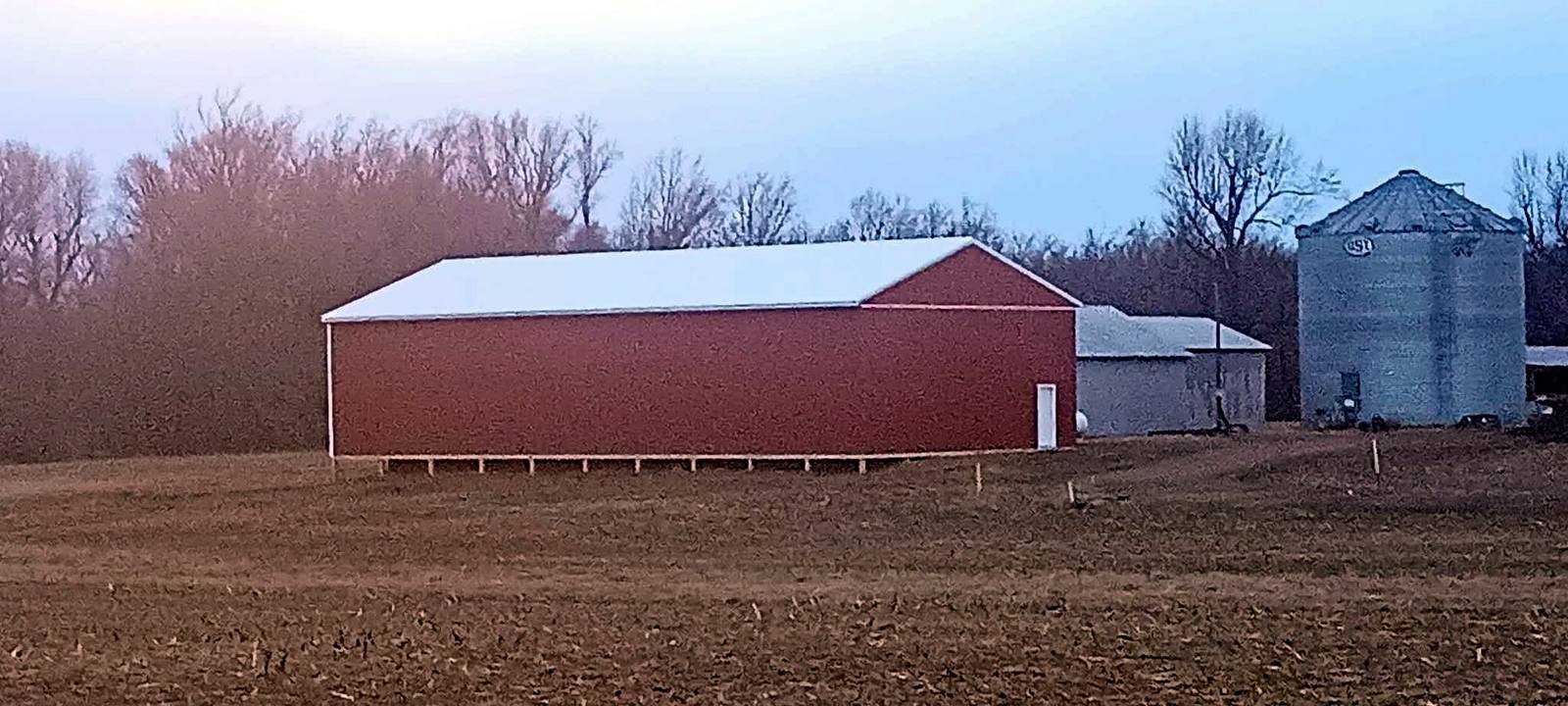 Finished red farm building beside a silo