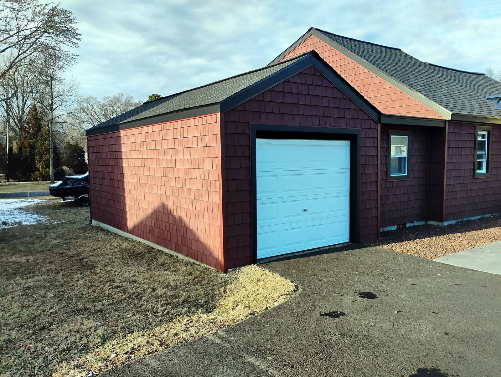 Finished red brick garage with dark overhead door
