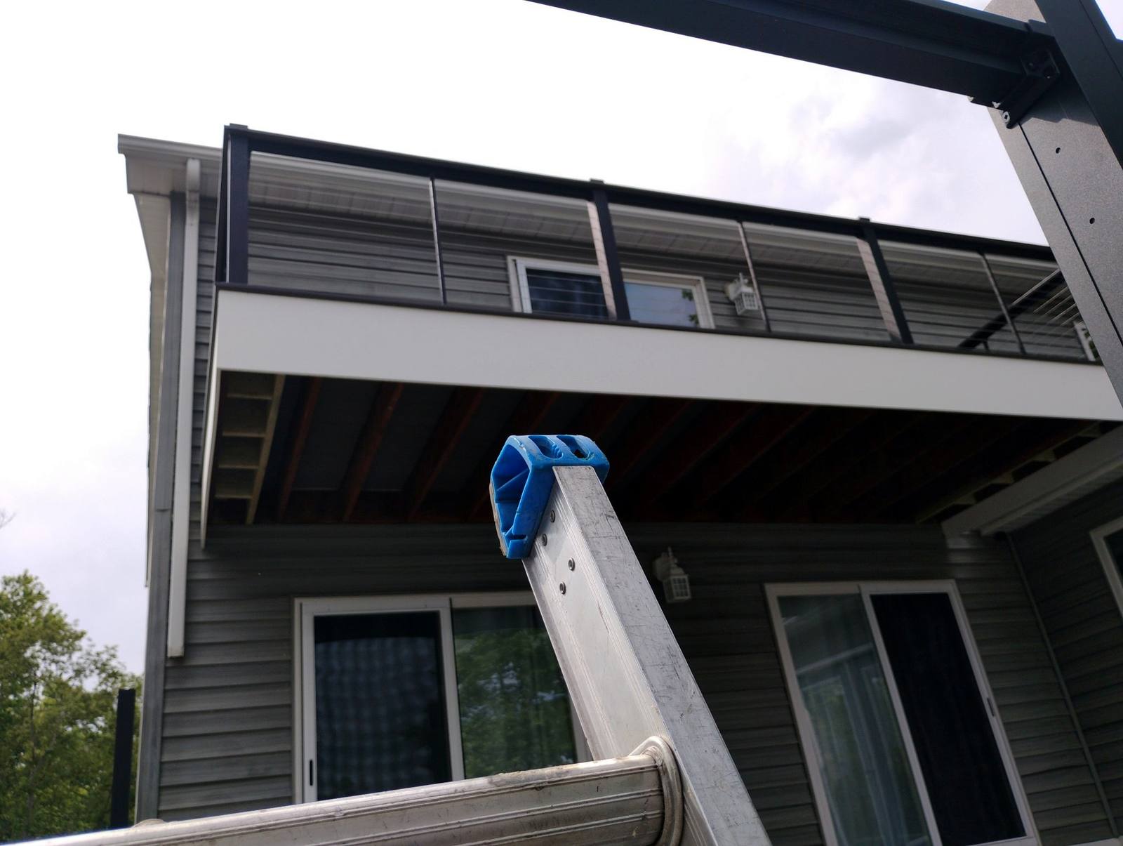 Black metal balcony railing on a gray home