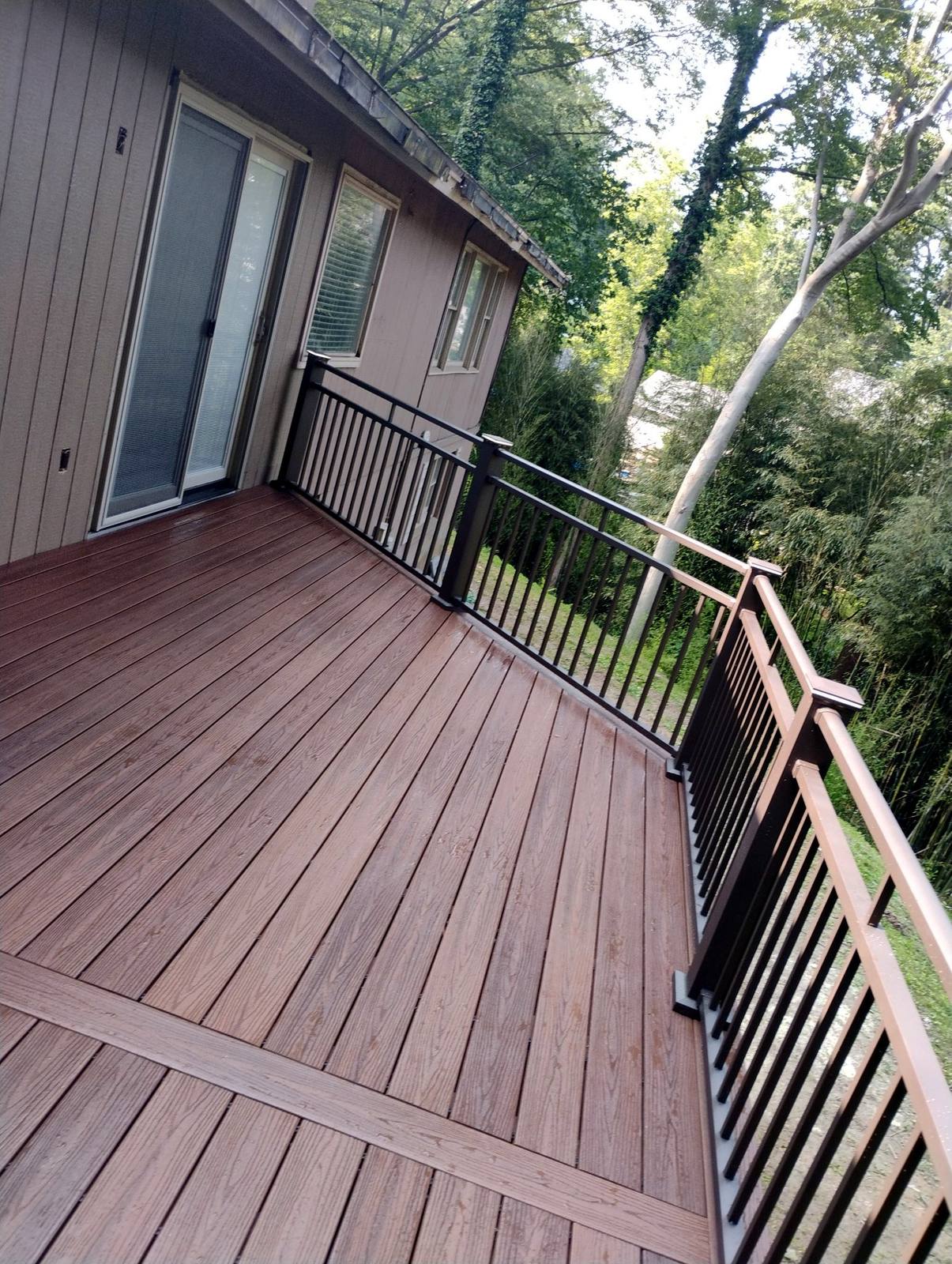 Finished brown deck boards beside a wooded yard