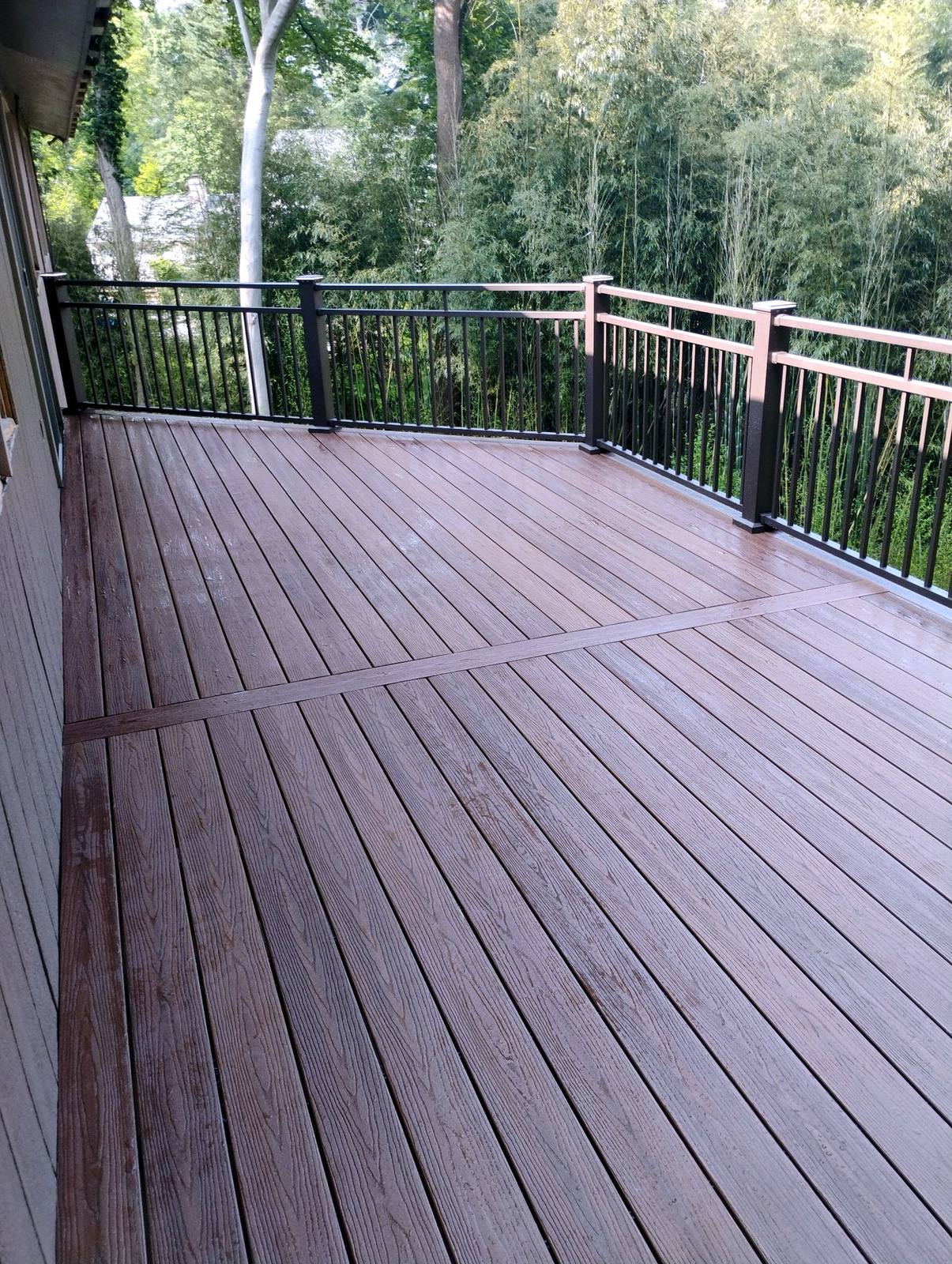 Wide finished deck floor with dark metal railing
