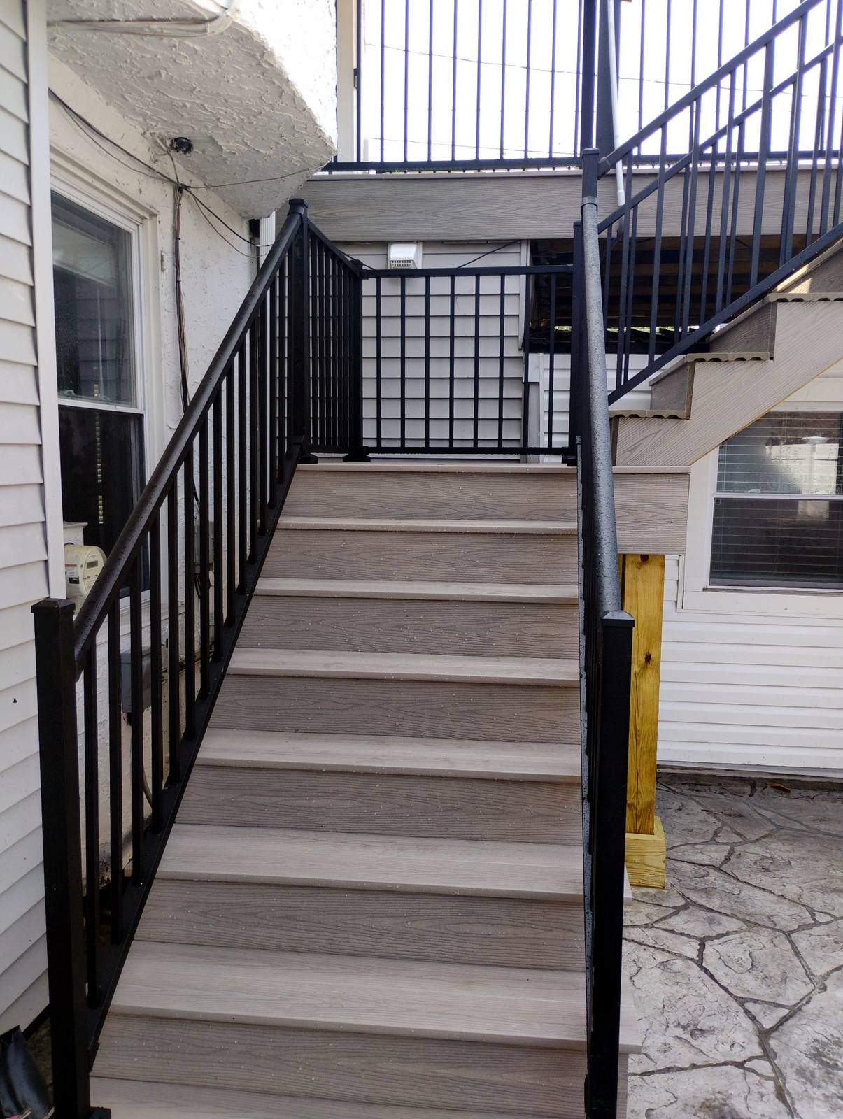 Gray composite exterior staircase with black metal railing