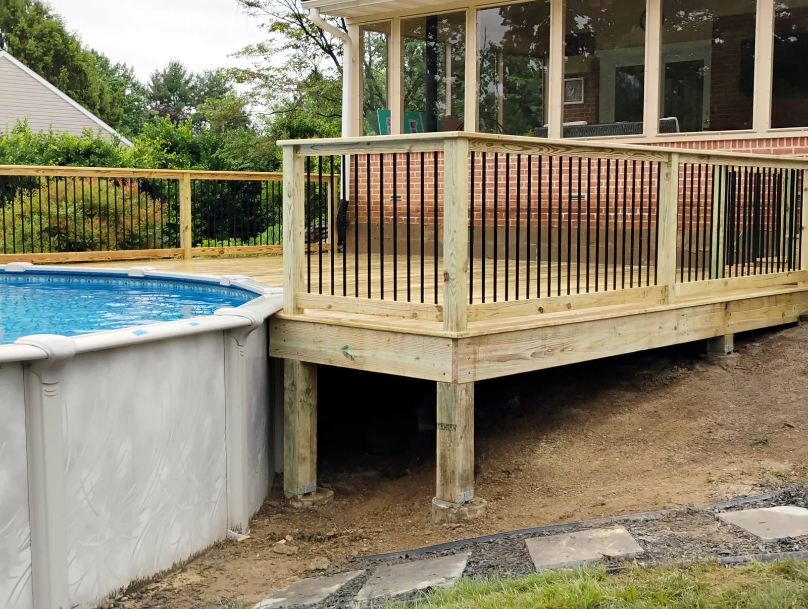 Finished wood deck beside an above-ground pool