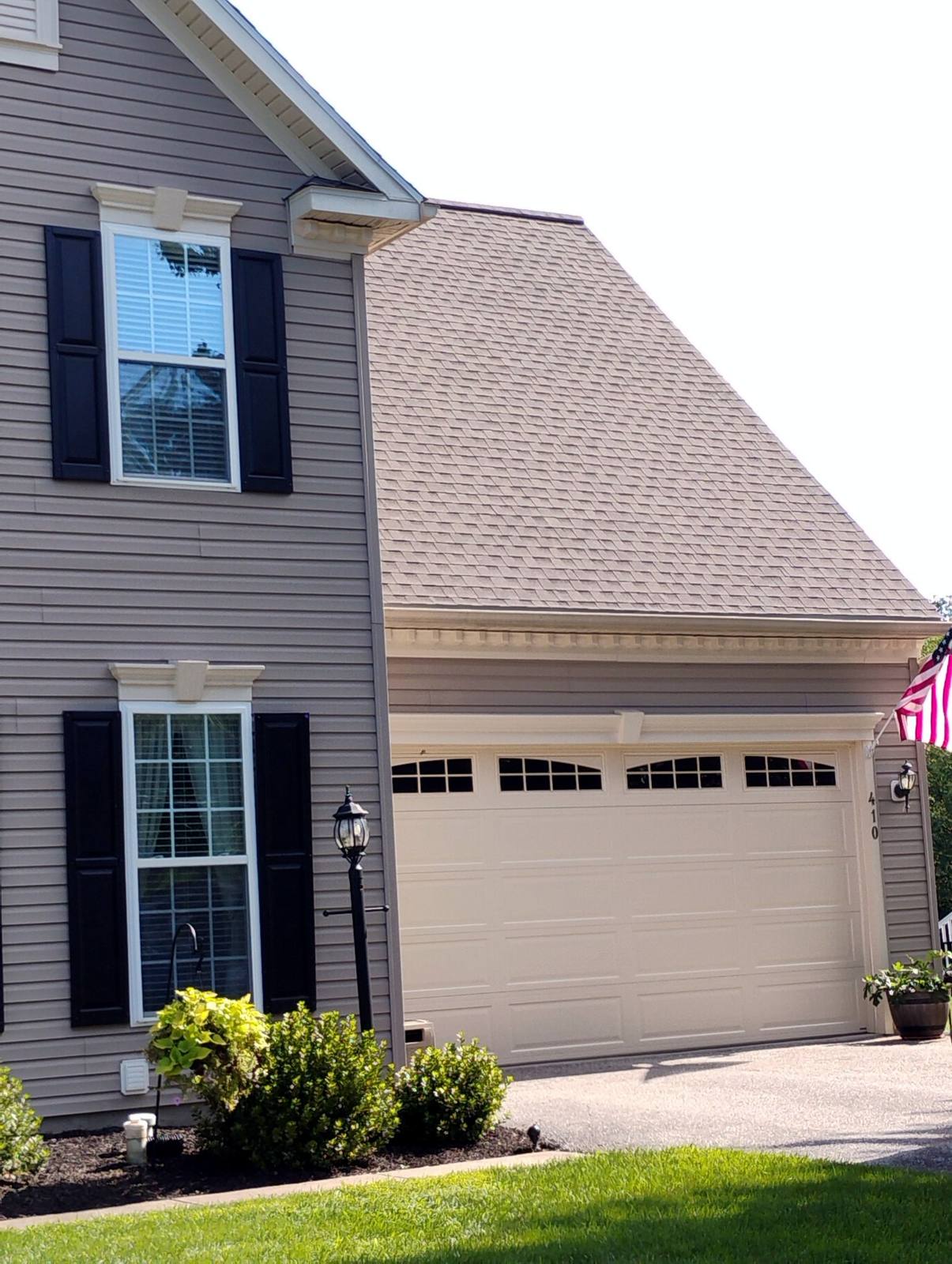 Finished garage addition with stone exterior and dark shutters