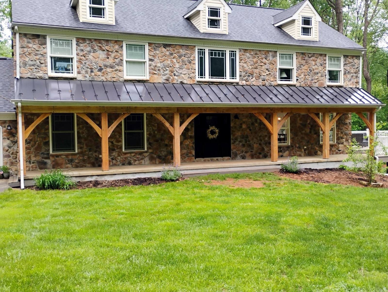 Wide finished timber porch on a stone home