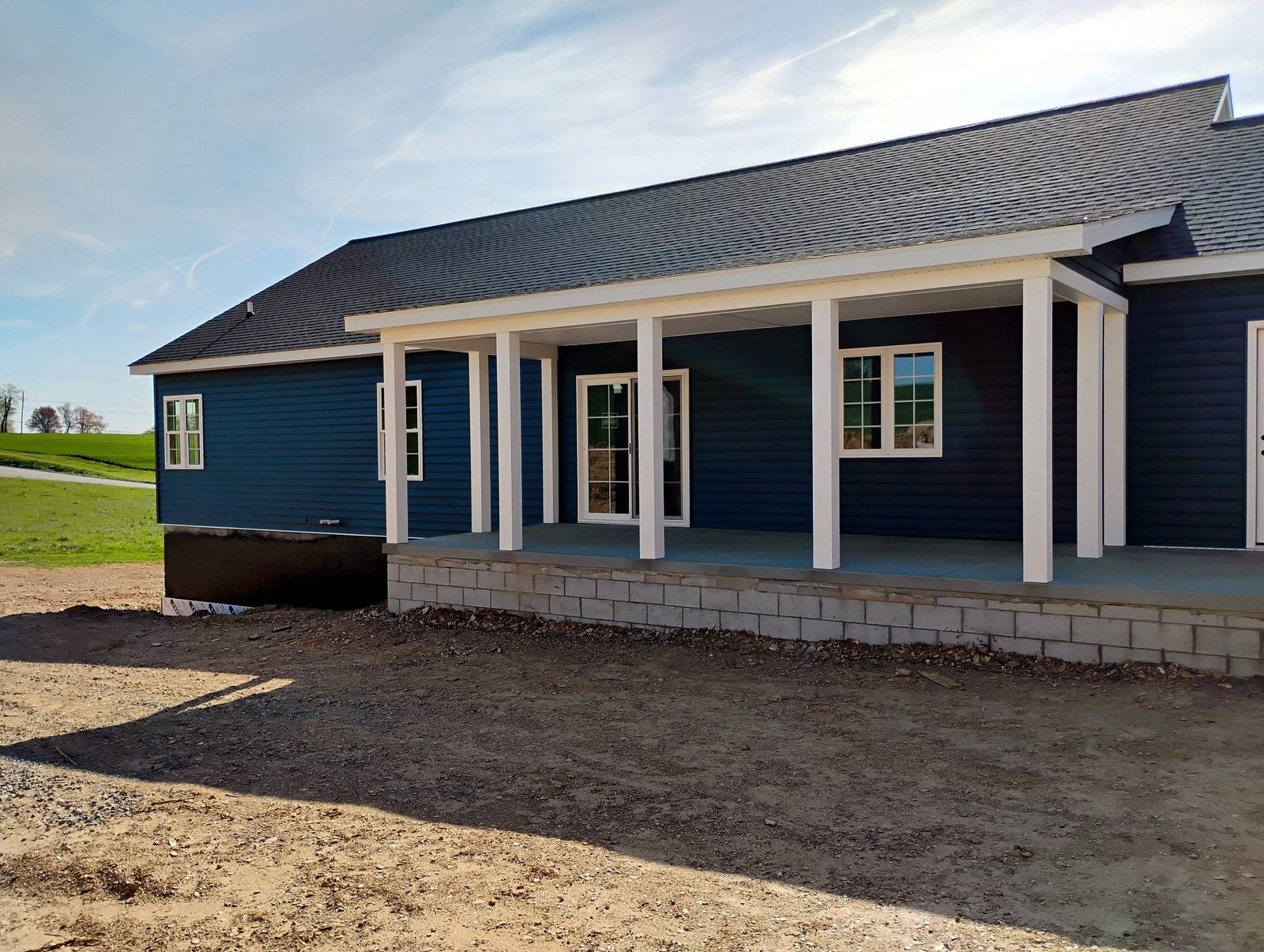 Completed dark-sided ranch home with a covered porch