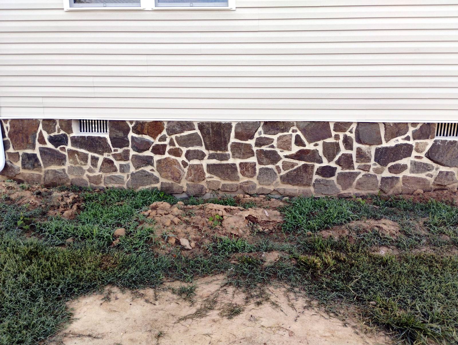Stone foundation detail along a finished home exterior