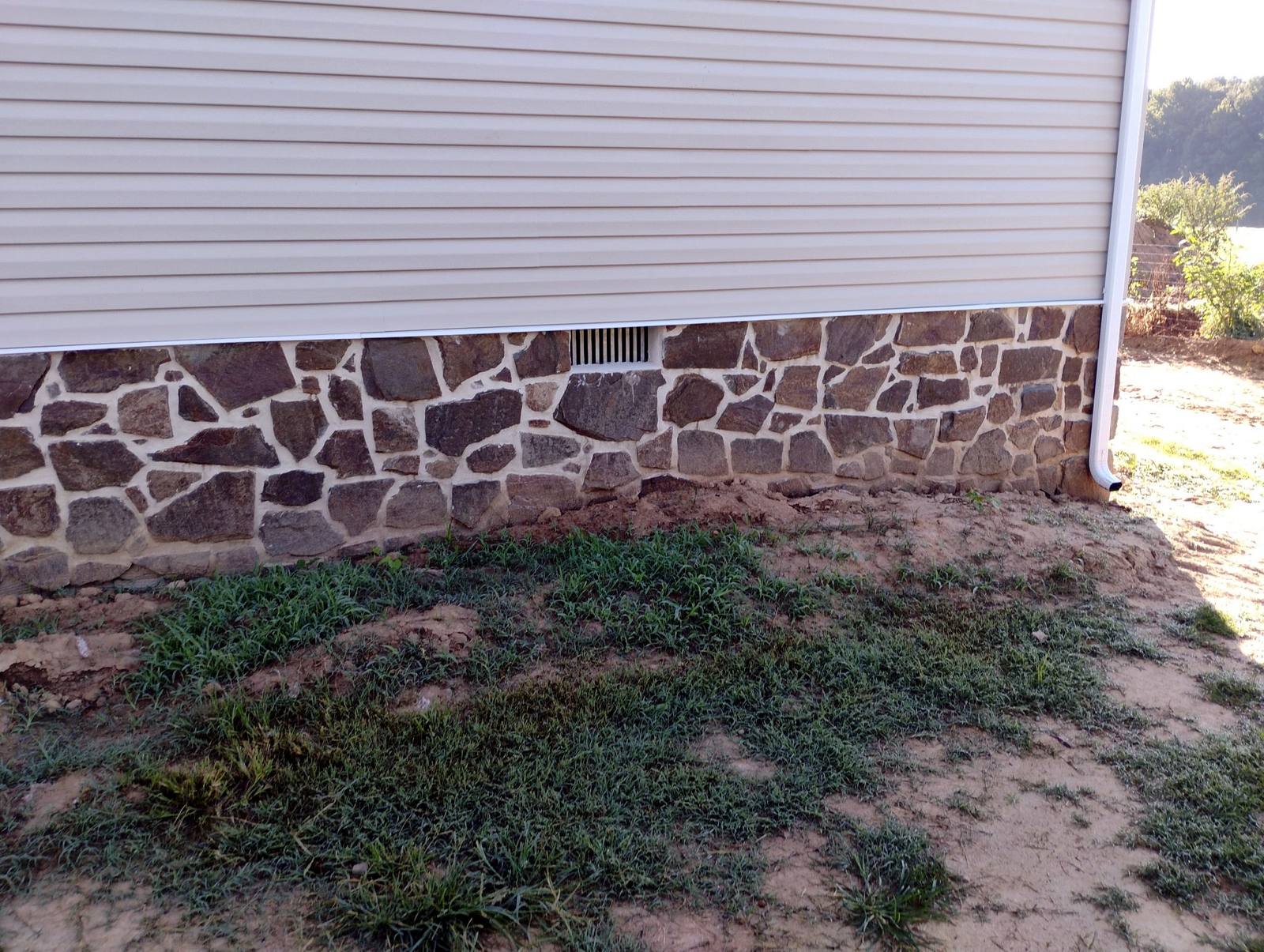 Completed stone foundation and light siding exterior