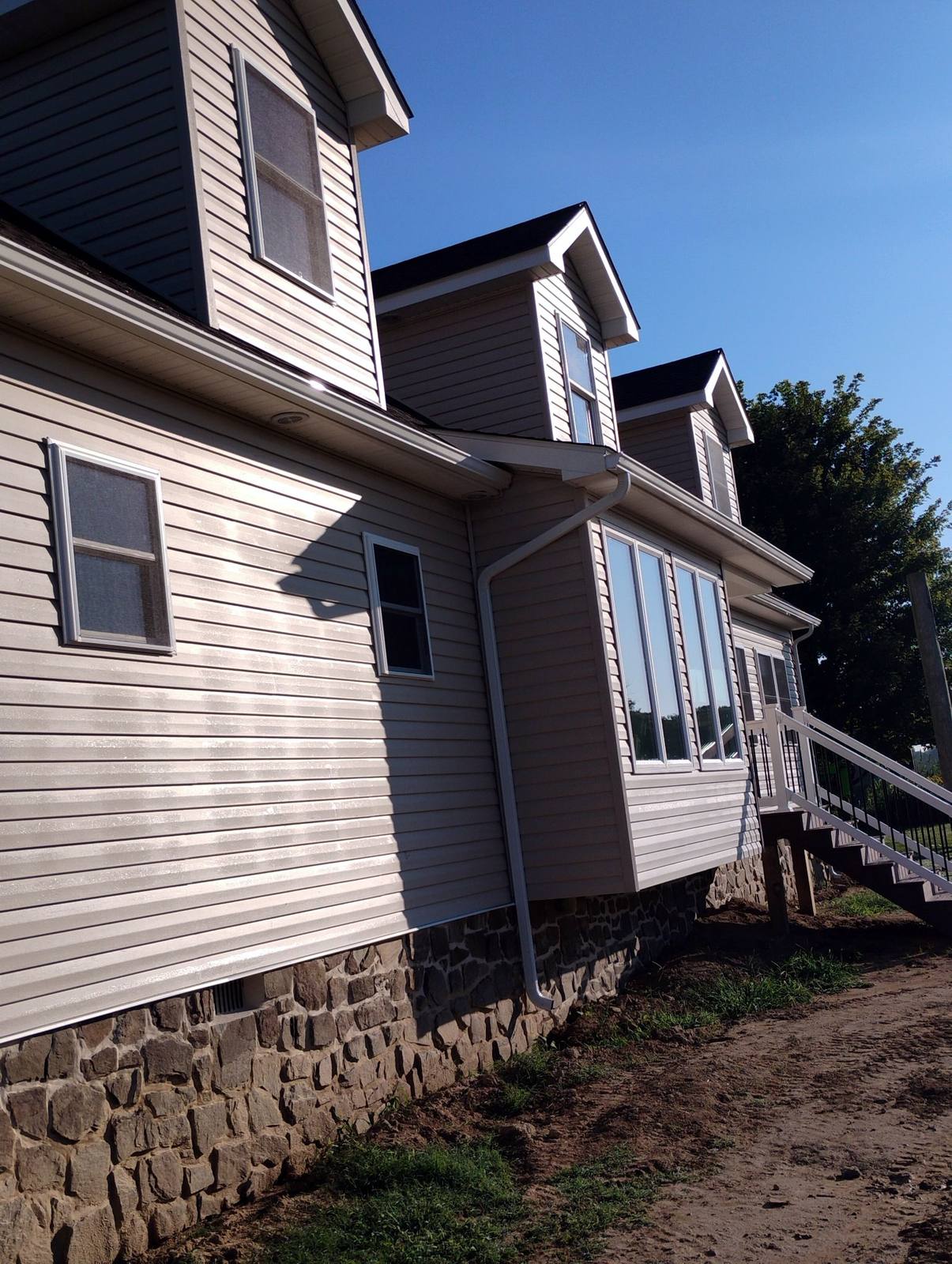 Side view of a completed white home with covered porch