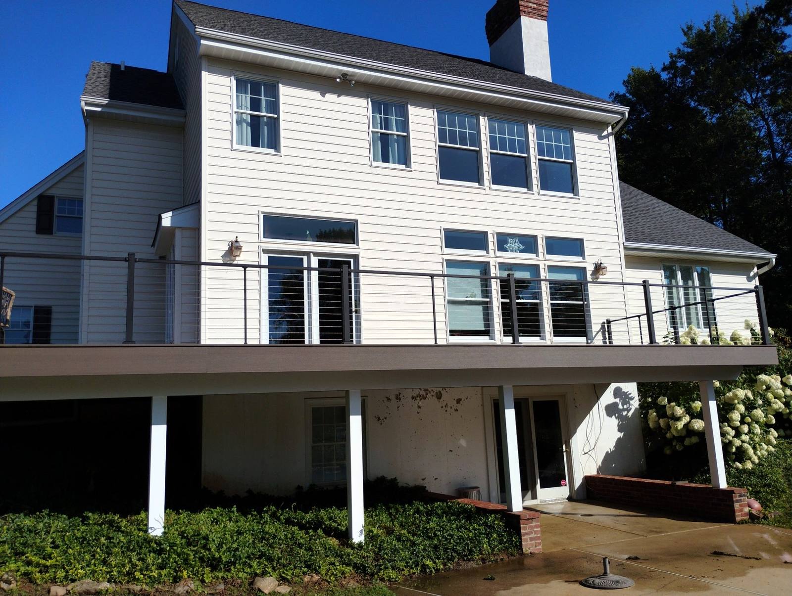 Completed raised deck across the rear of a white home