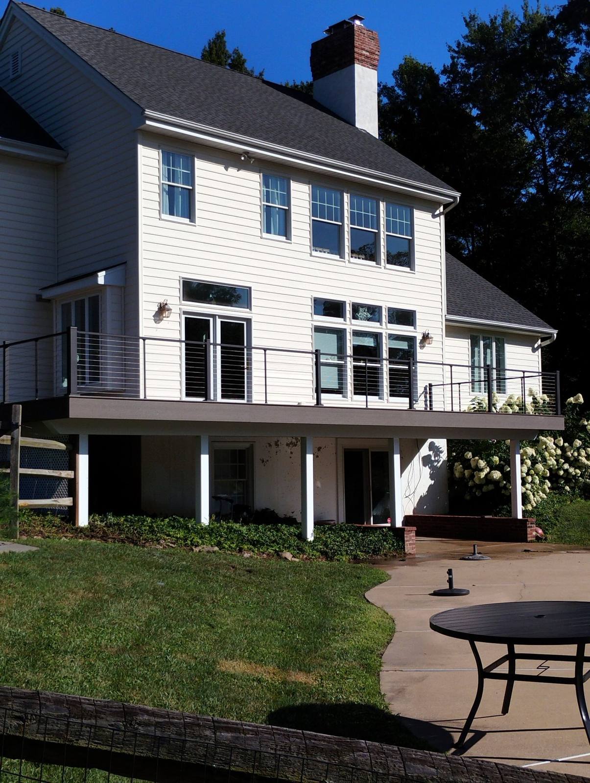 Completed white home with elevated rear deck