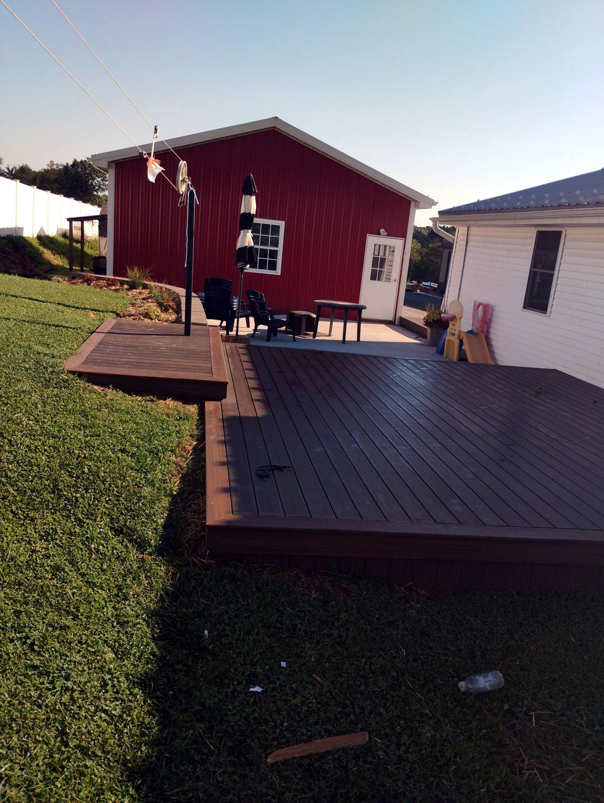 Completed brown deck beside a red outbuilding