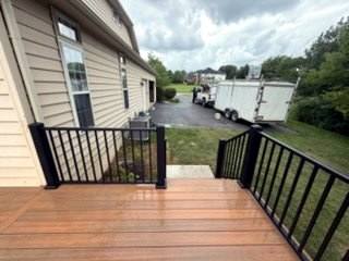 Wide brown deck beside a two-story home