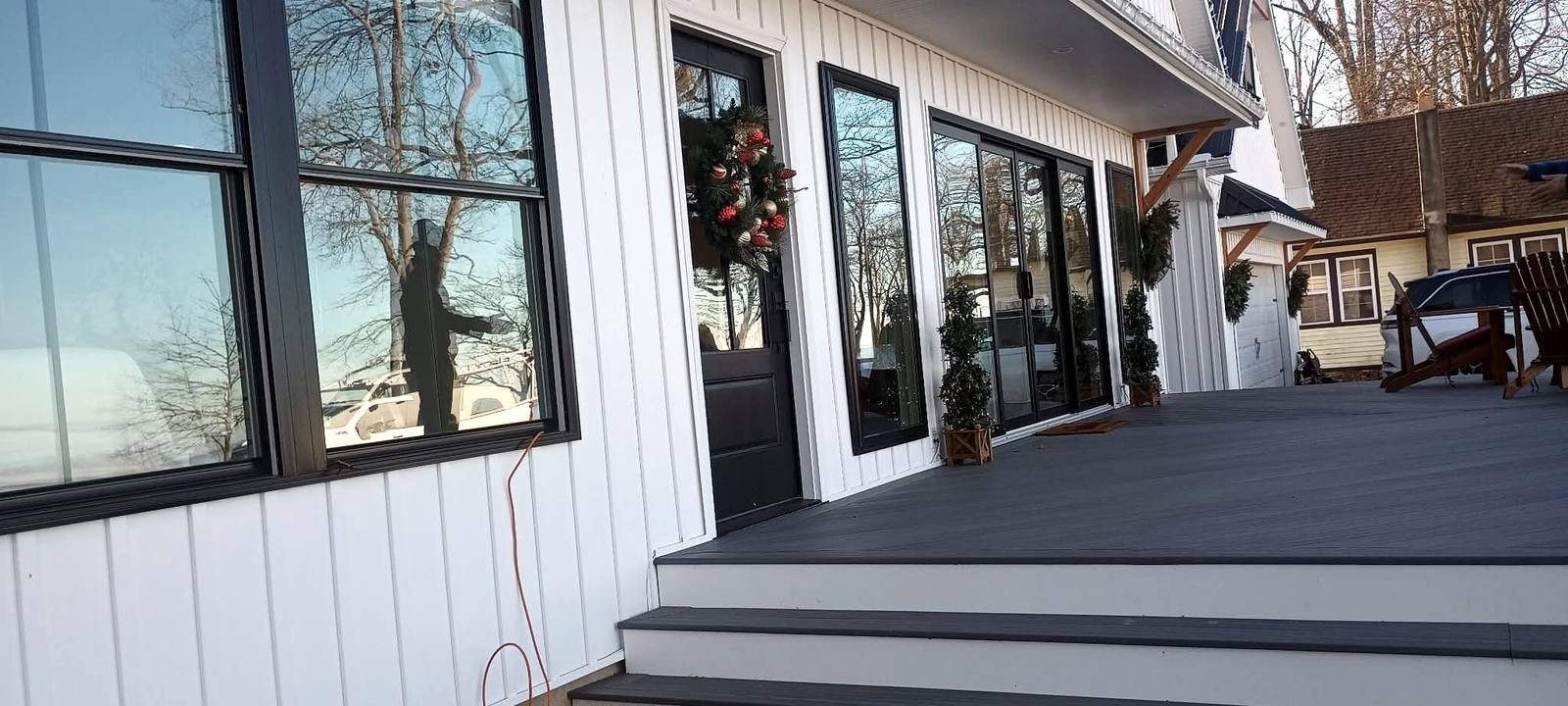 Finished gray porch deck beside a white home