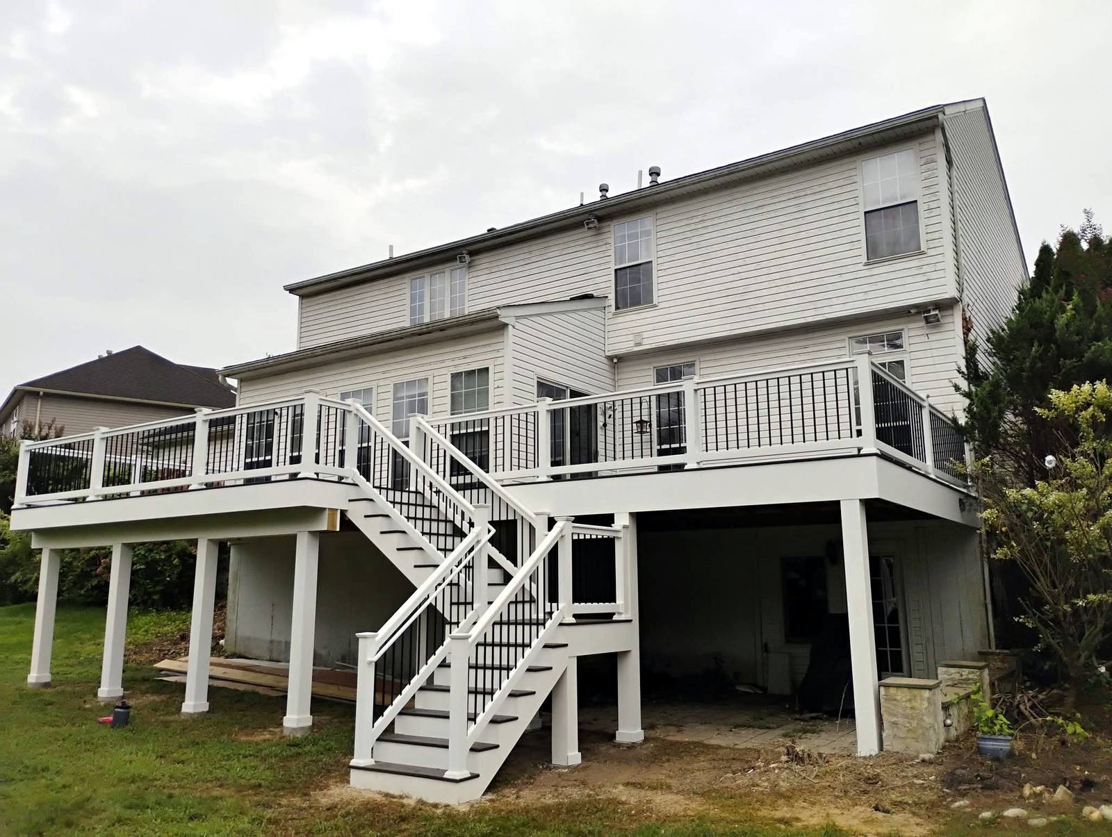 Completed raised deck with white posts and black balusters