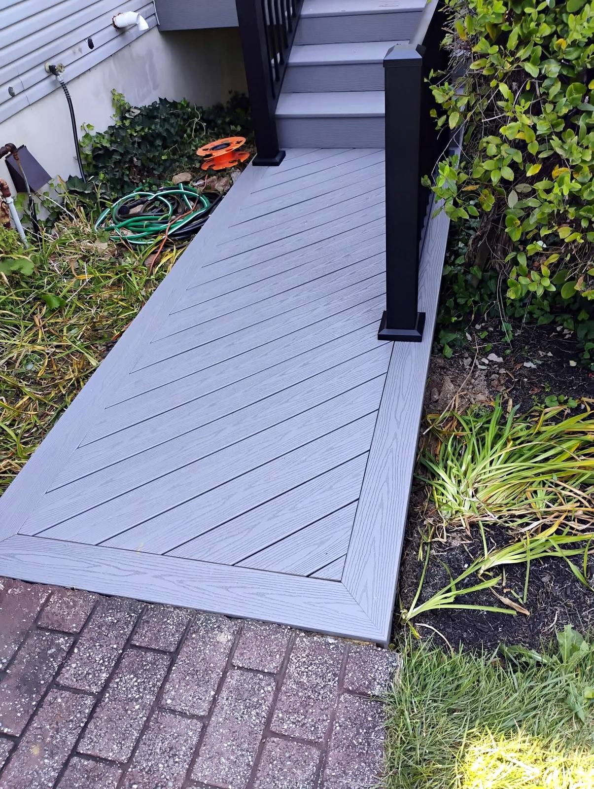 Gray composite walkway beside a finished home