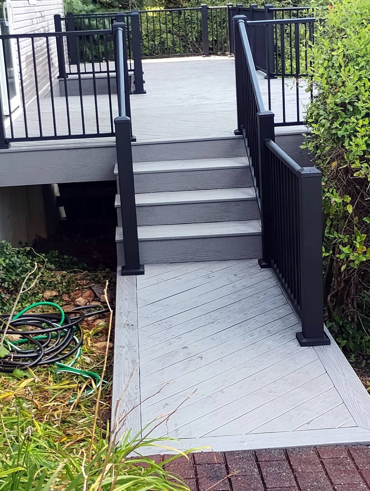 Gray deck stairs with black metal railing