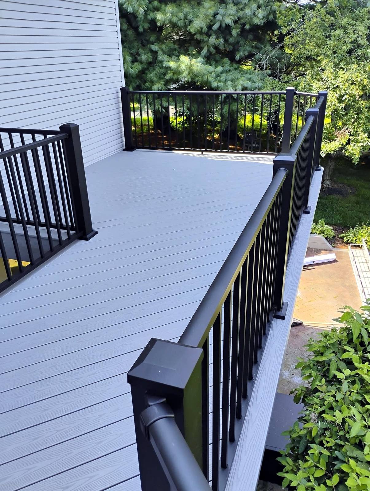 Narrow gray composite deck with black railing